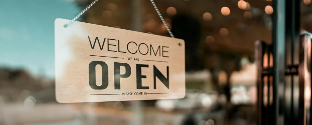 An open sign hanging on the door of a small business.