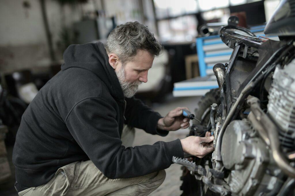 A mechanic works on a motorcycle at his auto repair shop.